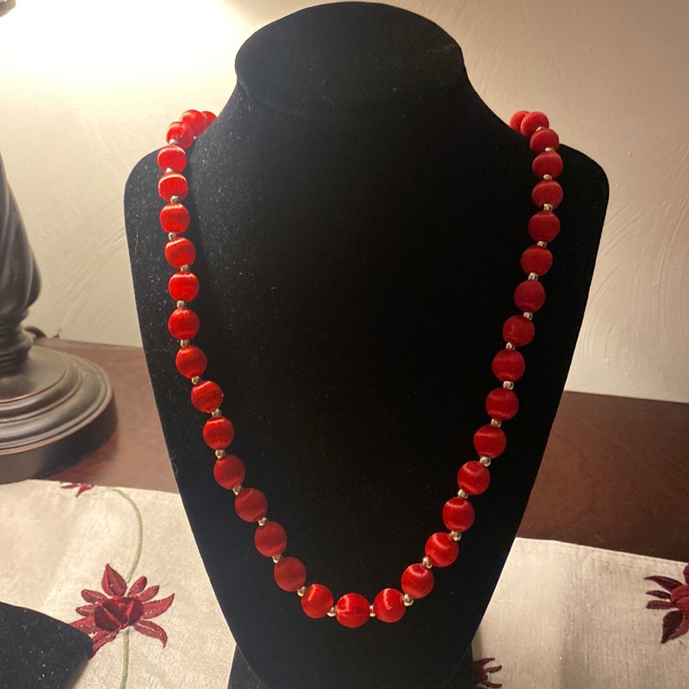 Red fabric covered beaded necklace.  Tiny silver beads between the red.